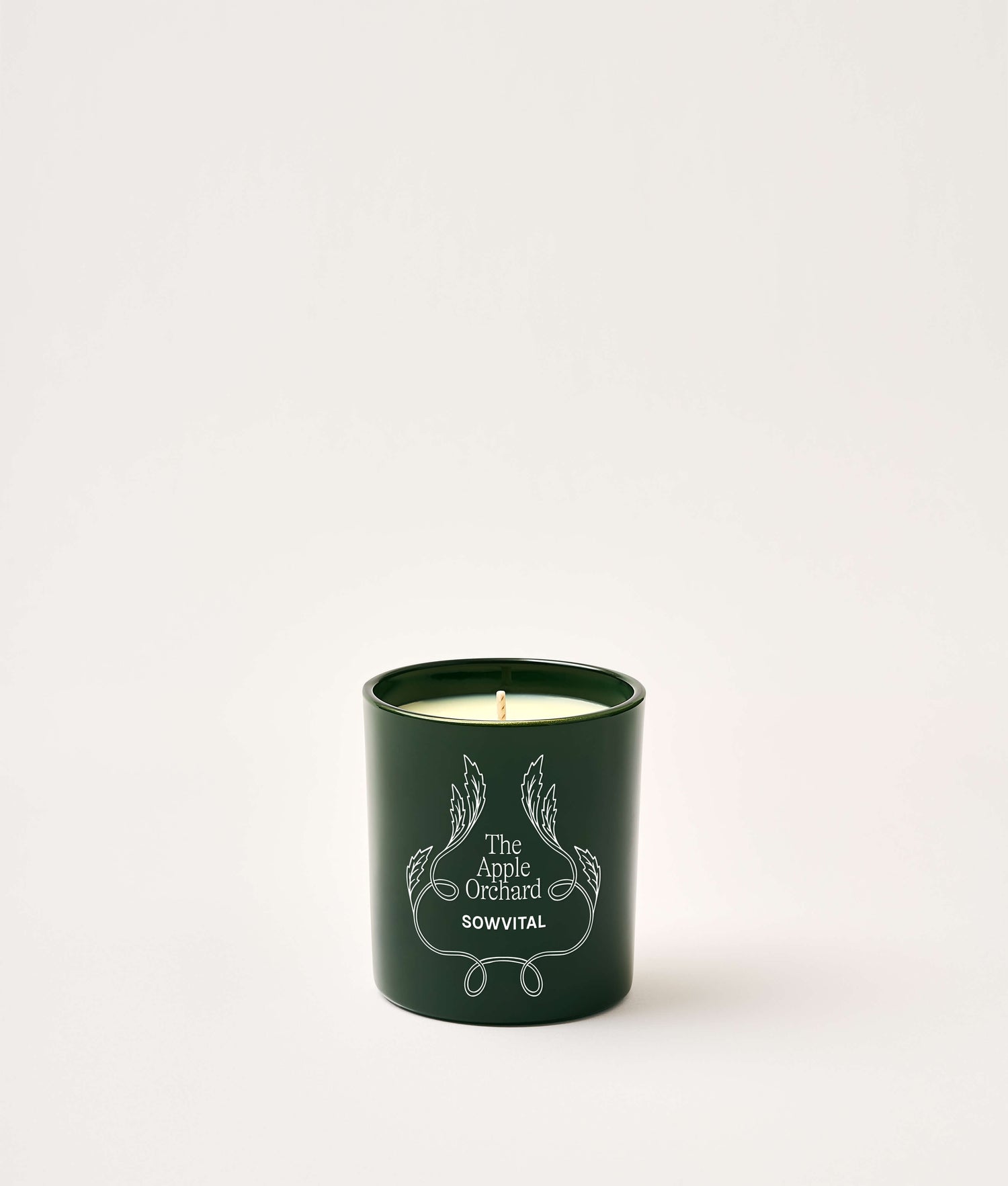 Green candle with 'The Apple Orchard' branding on a white background