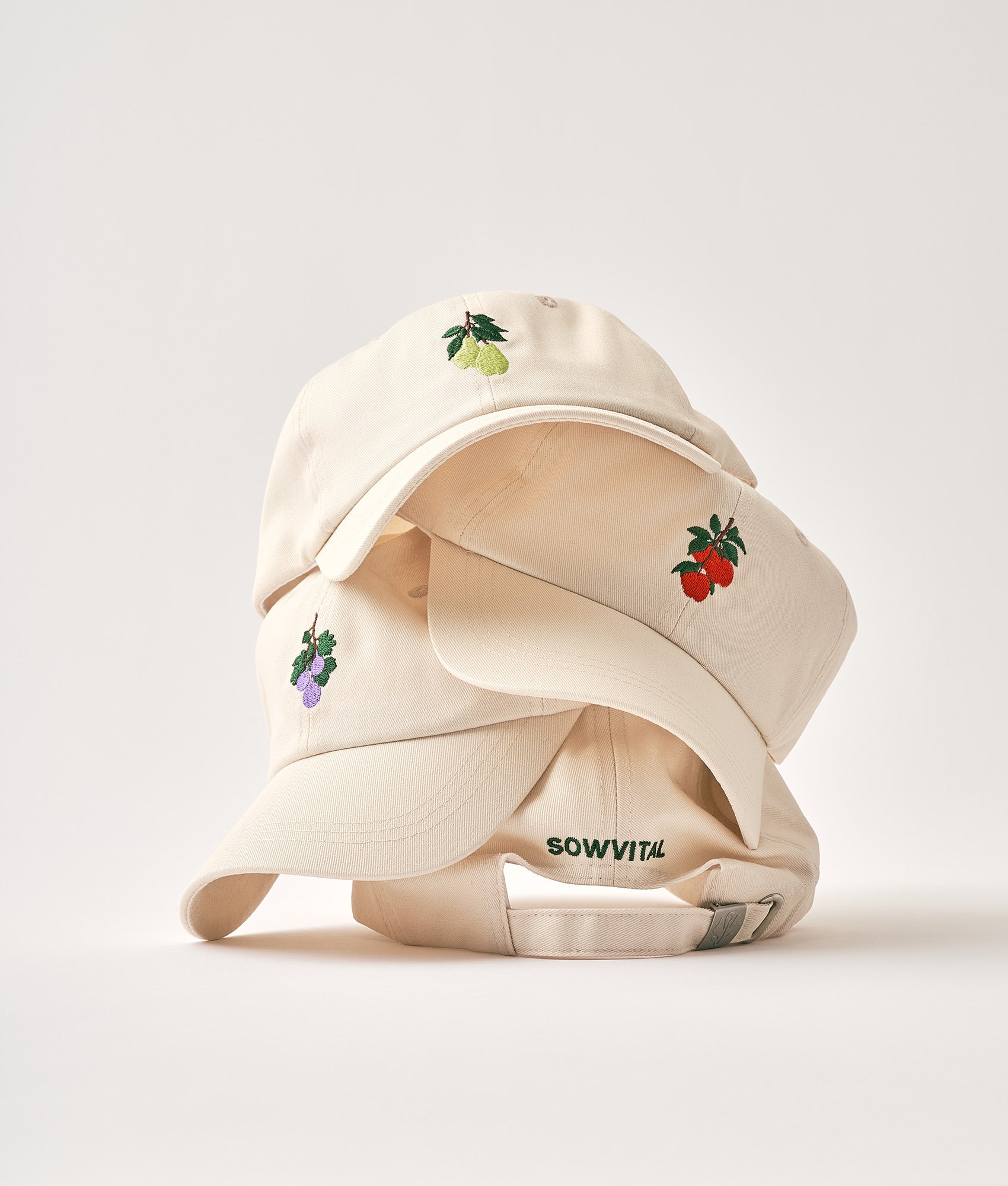 A stack of beige cotton caps with colourful motifs on each one.