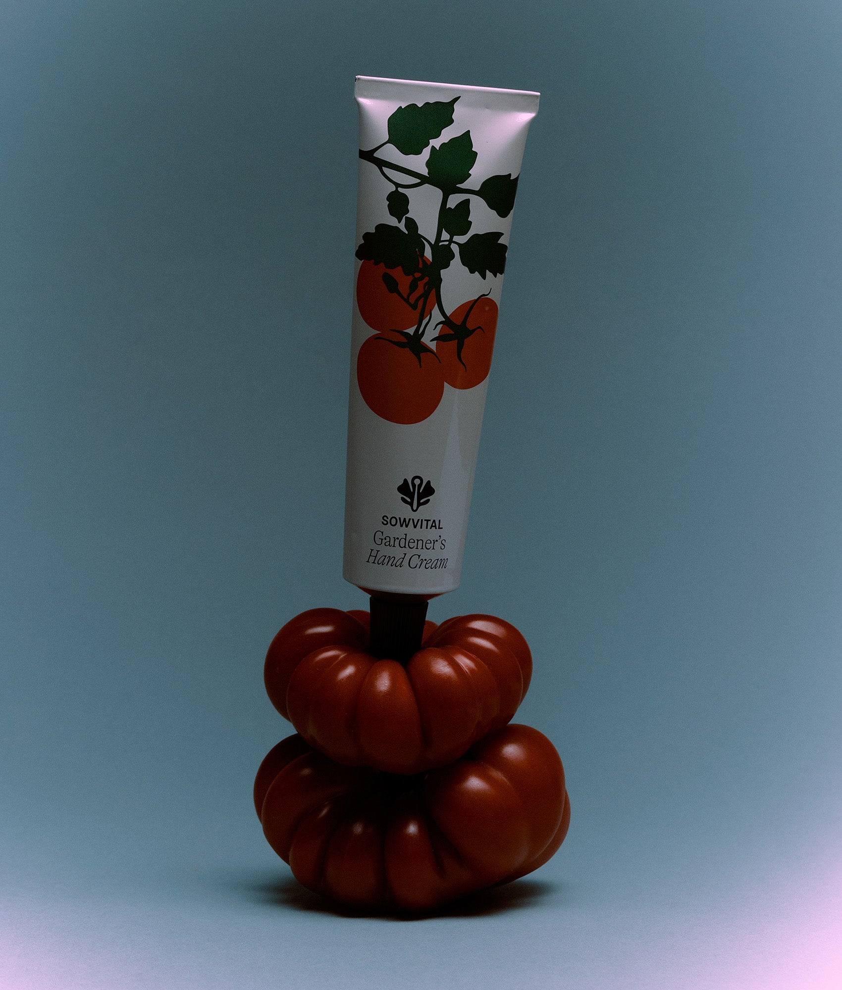 Hand cream tube with tomato design on a blue background