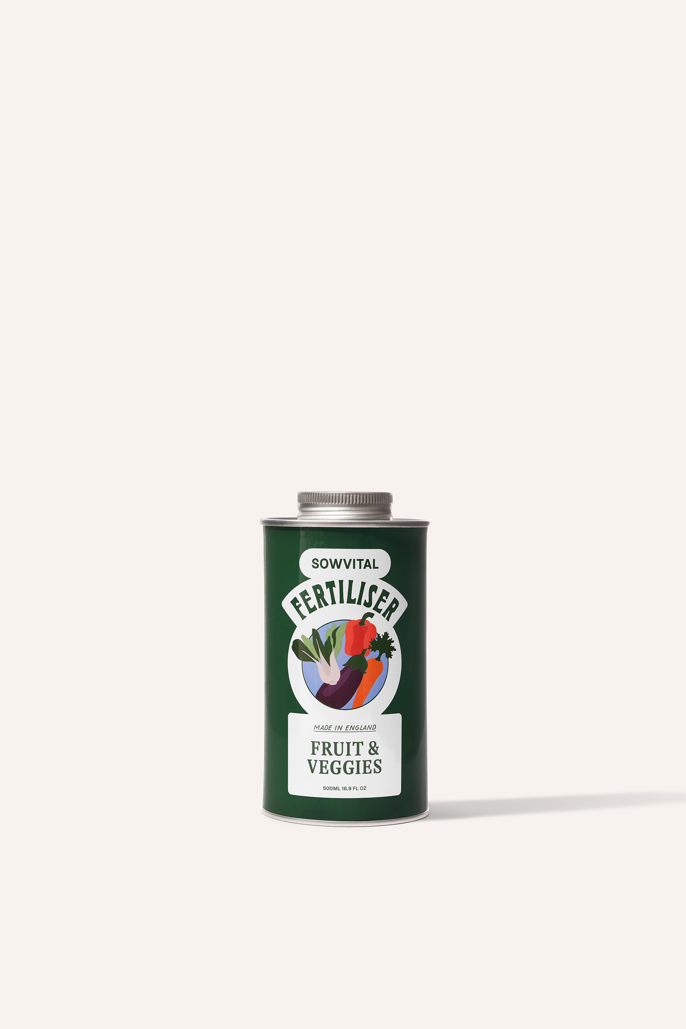 A tall round dark green metal tin of garden fruit & vegetable plant fertiliser in front of a beige background.