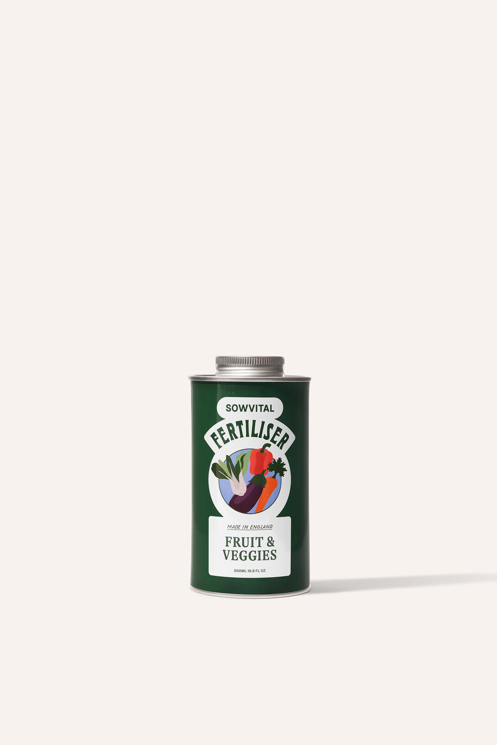 A tall round dark green metal tin of garden fruit & vegetable plant fertiliser in front of a beige background.