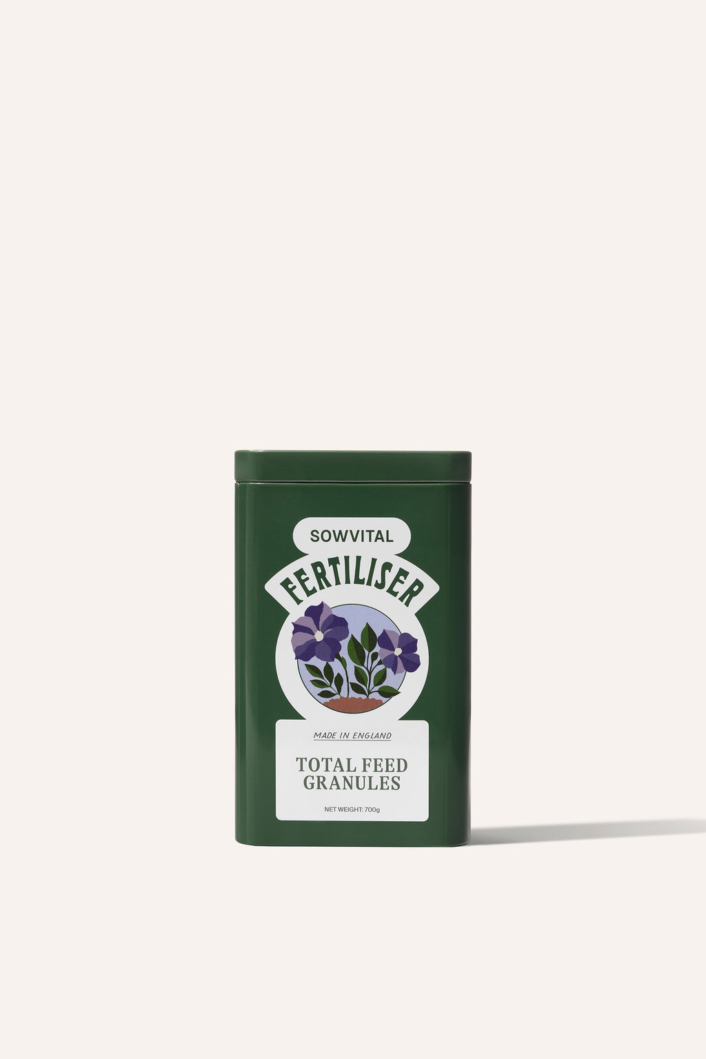 The front of a tall rectangular dark green metal tin of garden fertiliser granules on a beige background.