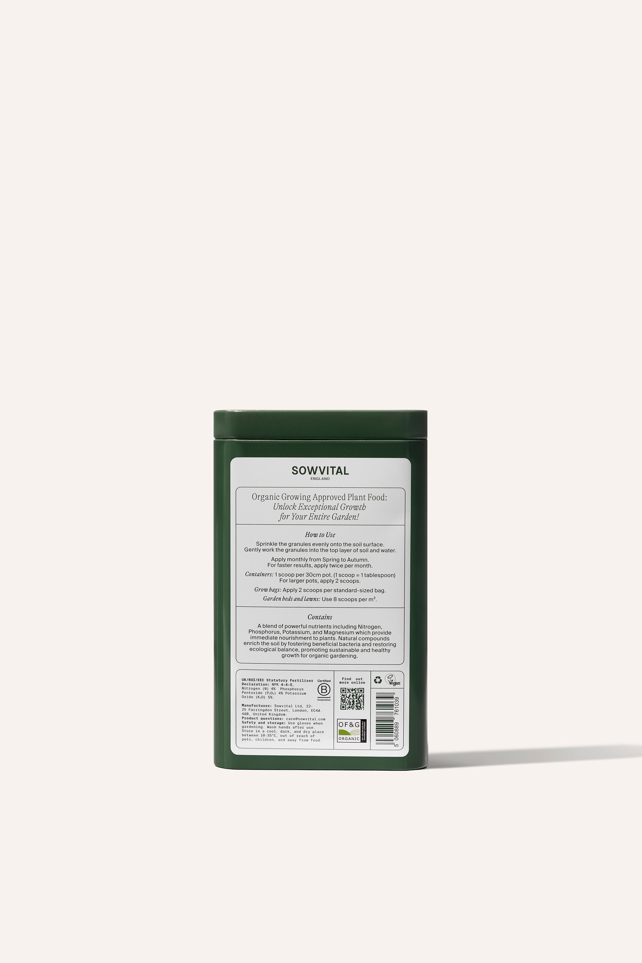 The reverse side of a tall rectangular green metal tin of garden fertiliser granules on a beige background.