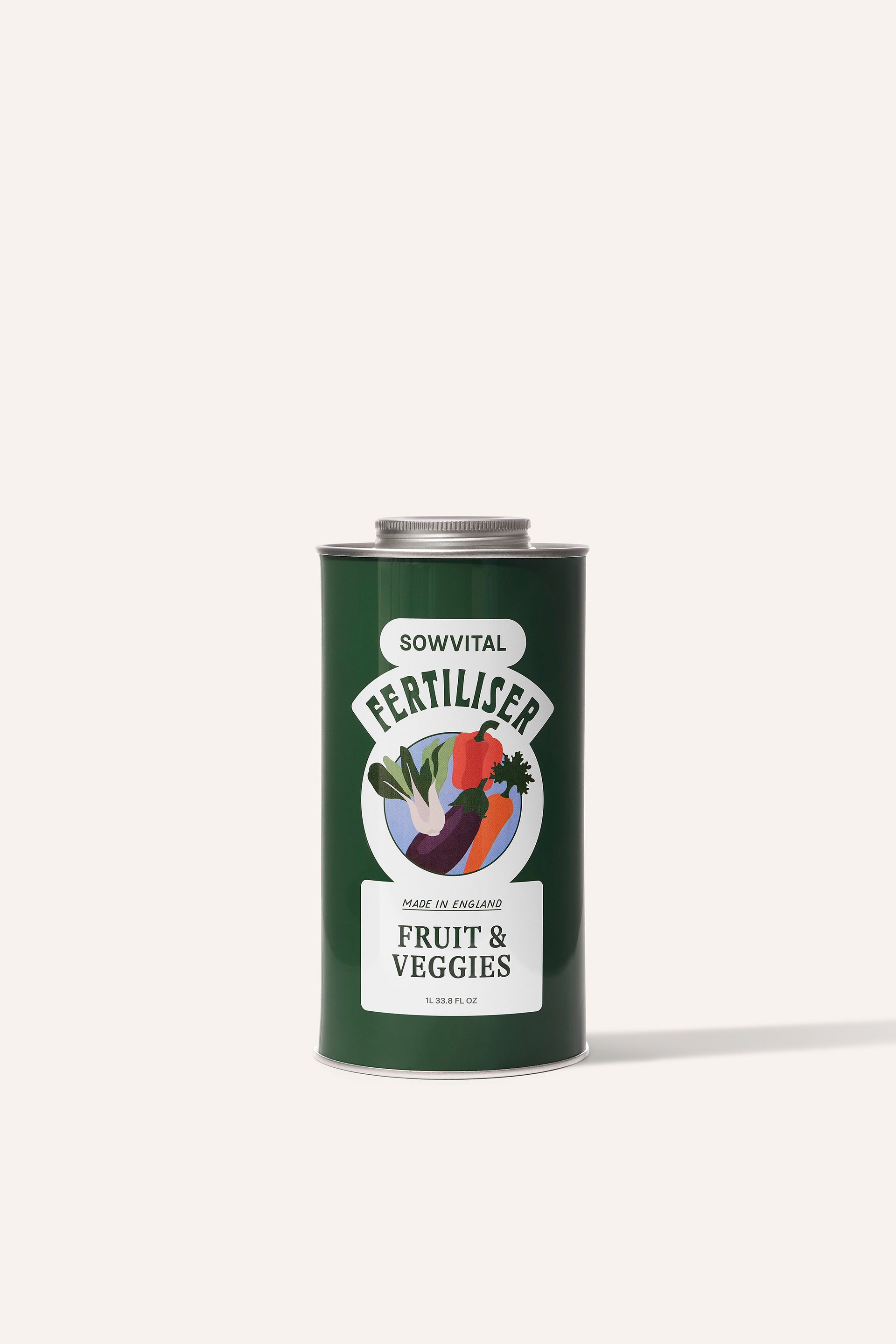 A tall round dark green metal tin of garden fruit & vegetable plant fertiliser in front of a beige background.