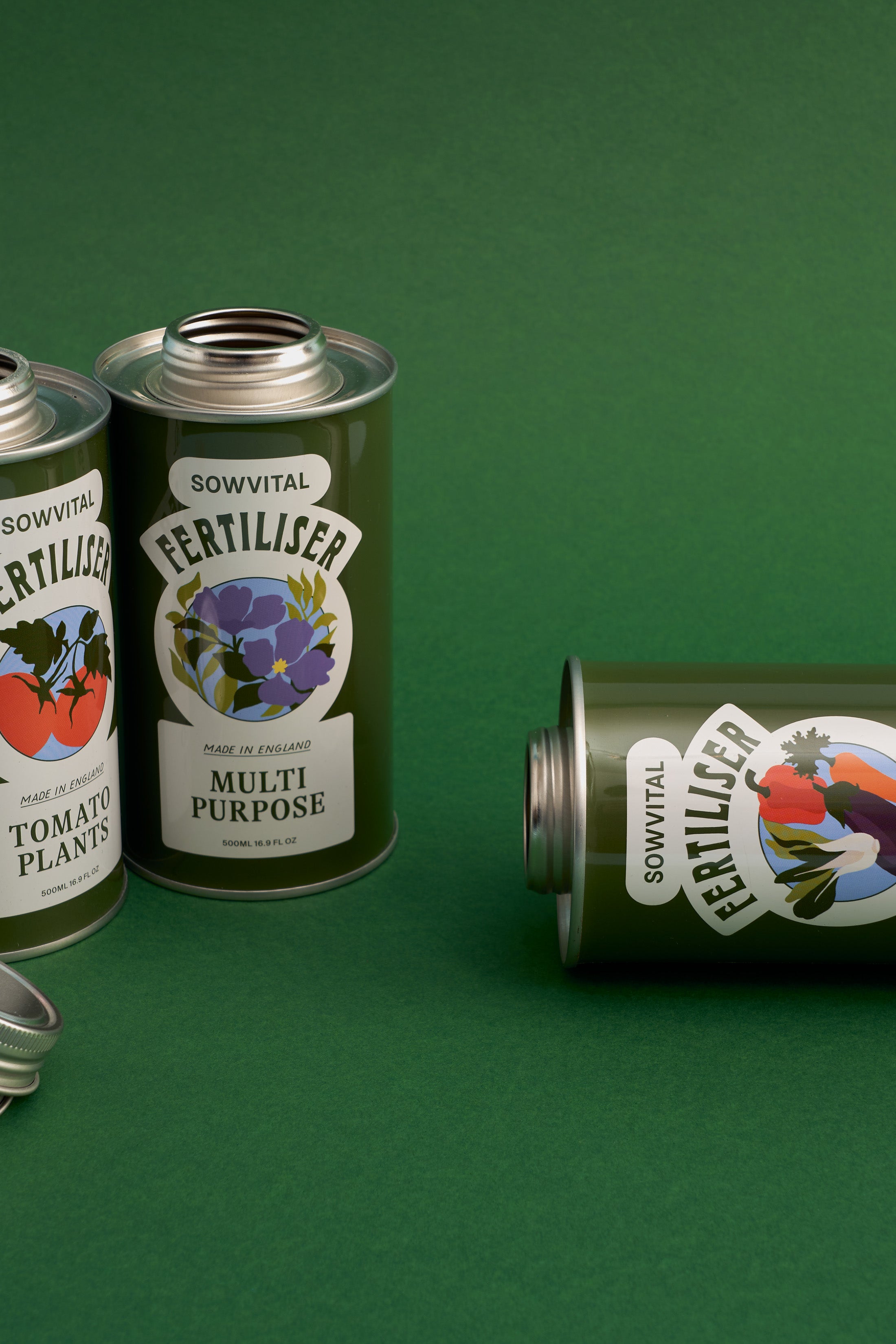 Three of Sowvital's garden fertilisers sit on a soft green background, with one laying on its side.