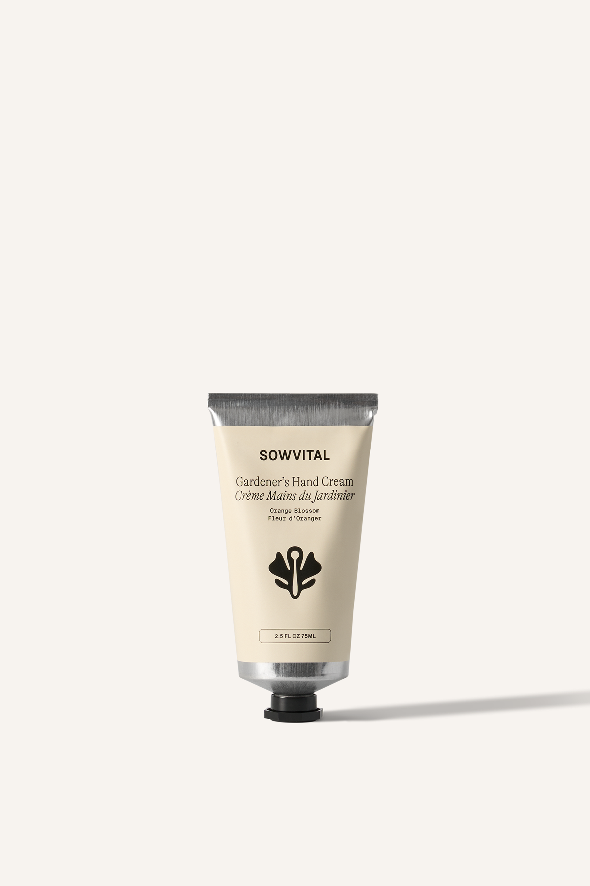 An aluminium tube of hand cream with a beige label and black lid, sat on its lid. The label has a large Sowvital logo in the centre. The background of the image is beige.