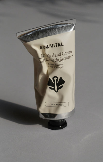 A shiny metal tube of handcream, with a beige label where the Sowvital logo is front and centre. The tube is slightly squashed, creating intriguing shadows across the label.