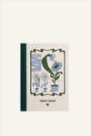 An A6 notebook with a beige cover and green cloth spine. The cover shows a green and blue illustration of a potted flower, watering itself with a watering can while being observed by two smaller flowers. The background of the image is beige.