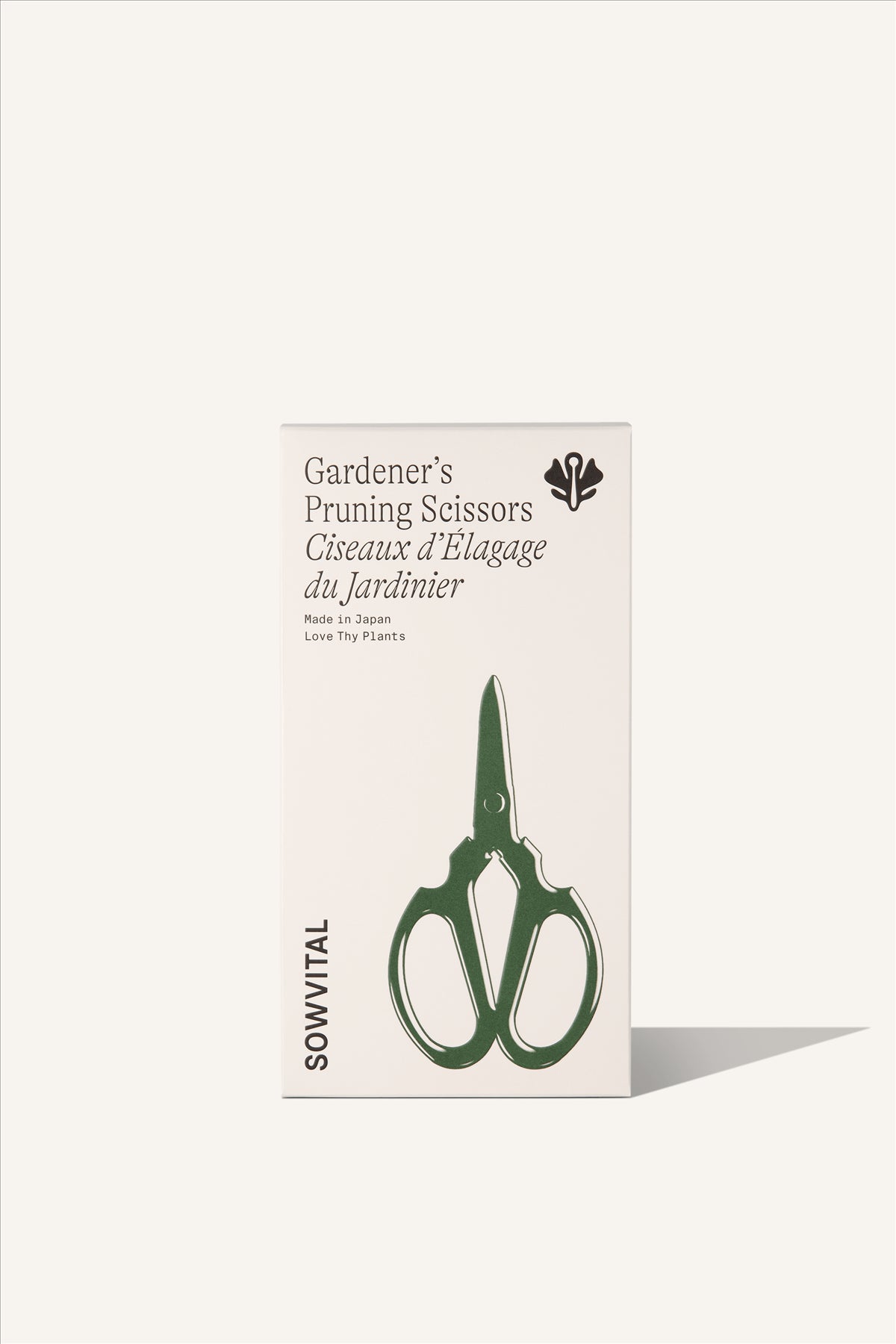 A tall rectangular beige fedrigoni paper box with a green embossed illustration on the front in the shape of the pruning scissors. The background of the image is beige.