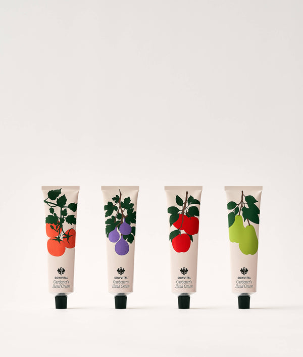 Four tubes of hand cream with fruit illustrations on a white background