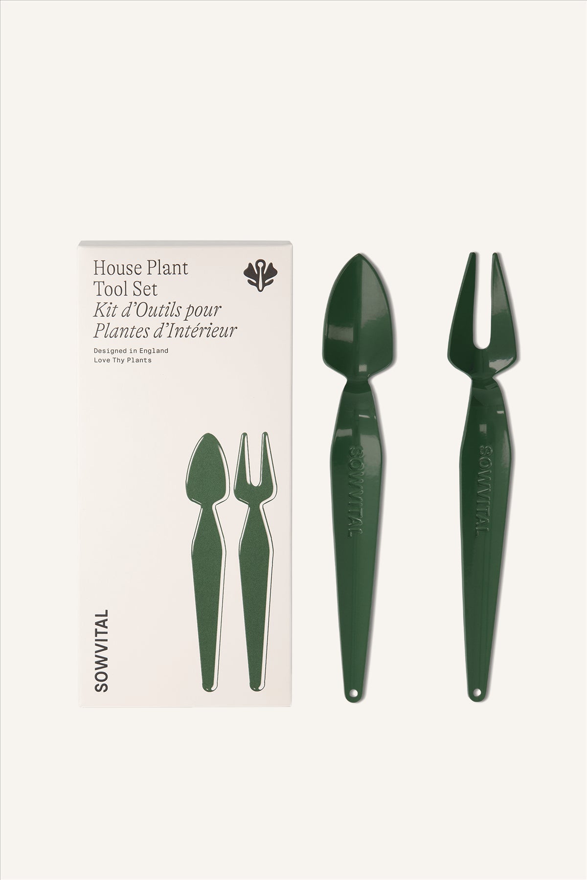 The House Plant Tool Set sat alongside its box. A tall rectangular beige fedrigoni paper box embossed with illustrations matching the tools sat alongside. Two stainless steel green hand tools, one fork and one trowel.