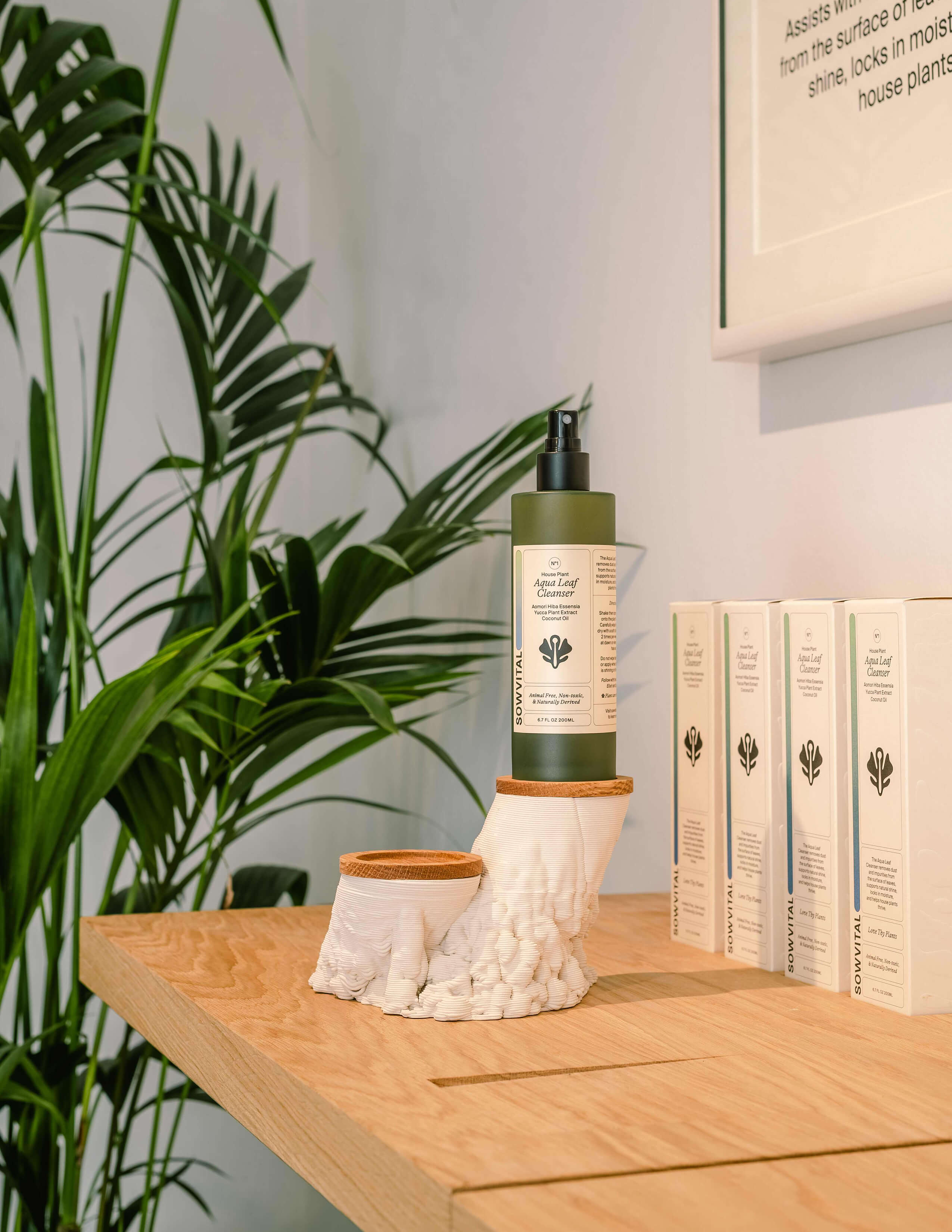A photograph different angle of the Sowvital product - Aqua leaf cleanser, is presented on the 3D printed ceramics and the packaging behind it.