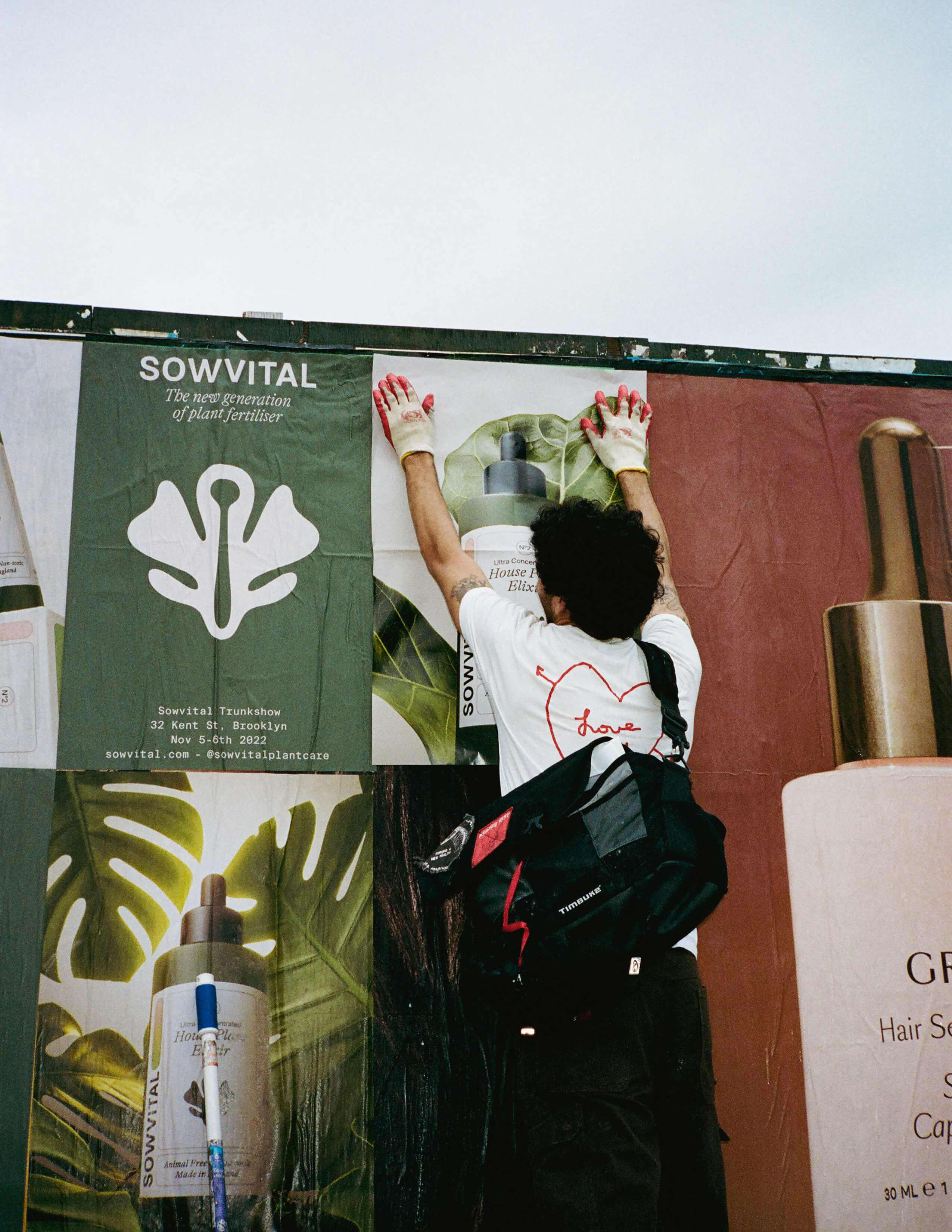 A person with gloves on was working on sticking the Sowvital posters on the board.