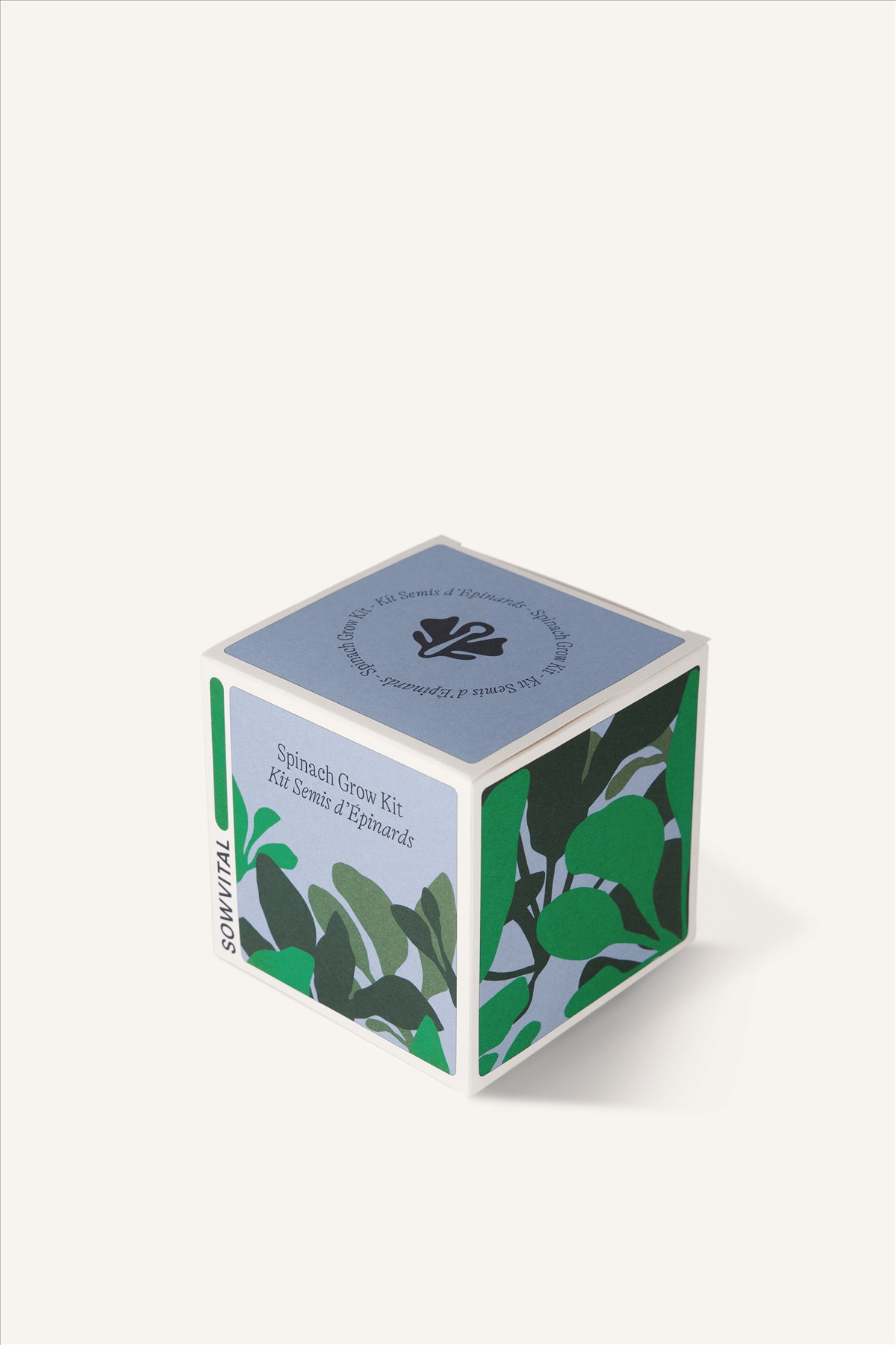 Sowvital's Spinach Seed Grow Kit from a corner angle. A square fedrigoni paper box with a playful illustration of spinach on the front and sides. The background is beige.