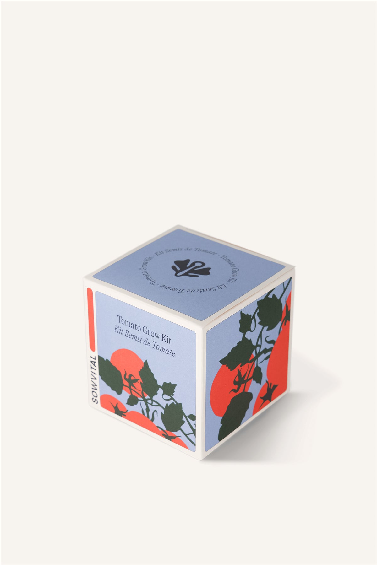 Sowvital's Tomato Seed Grow Kit from a corner angle. A square fedrigoni paper box with a playful illustration of tomatoes on the front and side. The background is beige.