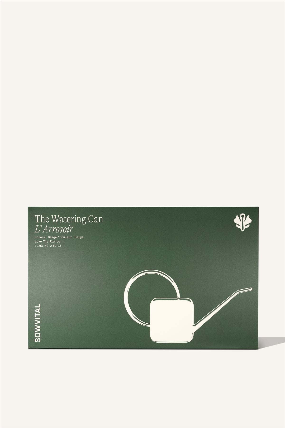 A large rectangular green paper box, embossed with an illustration of the beige watering can contained inside.