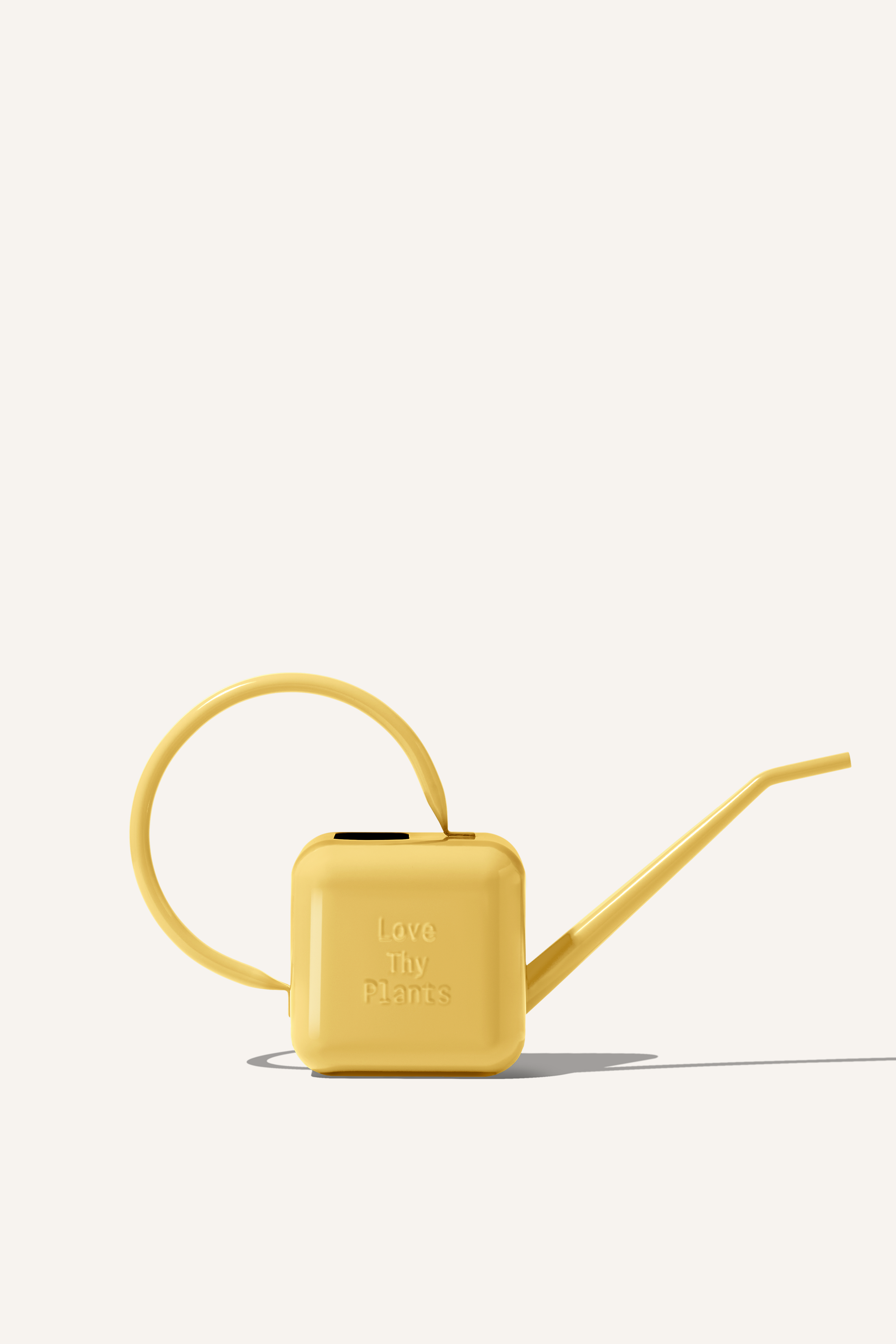 A yellow stainless steel watering can, embossed with the phrase "Love Thy Plants".